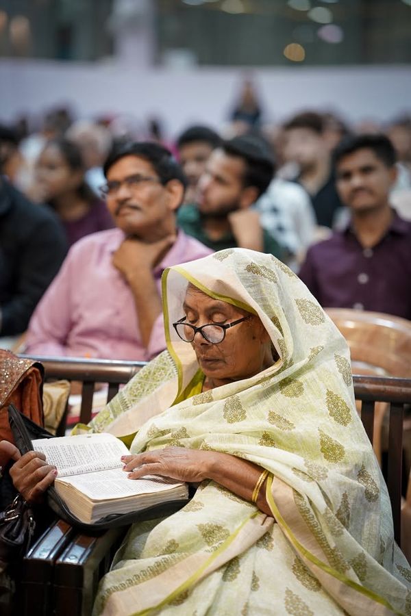 An older woman reading her Bible during the service