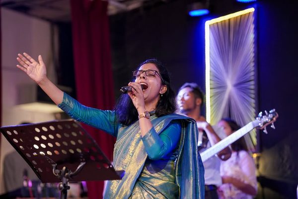 A woman singing with her eyes lifted