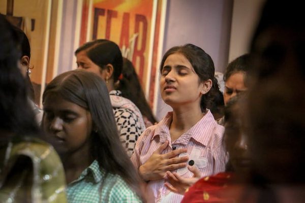 Young women praying with eyes closed